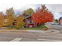 Red bungalow home with vibrant fall trees in the front yard at 103 S Park Ave, Fort Lupton, CO 80621
