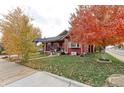 Red bungalow with fall foliage and a landscaped yard at 103 S Park Ave, Fort Lupton, CO 80621