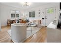 Cozy living room features hardwood floors, a leather couch, two chairs, and ample natural light at 4419 W 34Th Ave, Denver, CO 80212