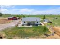 Scenic aerial view of a ranch-style house with a large front yard, adjacent pastures, and a red barn at 10691 County Road 23, Fort Lupton, CO 80621