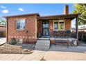 Brick ranch home with a landscaped lawn and a covered porch at 4747 Shoshone St, Denver, CO 80211