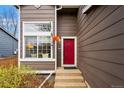 Stylish red front door and large window enhance the curb appeal of this charming home at 2574 Cove Creek Ct, Highlands Ranch, CO 80129