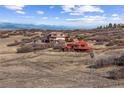 Expansive aerial view of the luxury home and its surroundings, featuring rolling hills and mountain views at 2505 Big Bear Cir, Sedalia, CO 80135