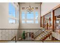 Stunning foyer with high ceilings, a grand chandelier, large windows, and a wrought iron staircase at 2505 Big Bear Cir, Sedalia, CO 80135