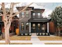 Beautiful exterior view of a dark brick home with a welcoming front porch and manicured lawn at 2753 Curtis St, Denver, CO 80205