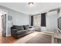 Inviting living room with a comfortable gray couch, radiator, and hardwood floors at 1024 E 14Th Ave # 10, Denver, CO 80218