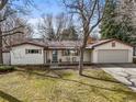 Charming single-story home with a well-manicured front yard and a two-car garage, showcasing classic curb appeal at 10050 W 8Th Pl, Lakewood, CO 80215