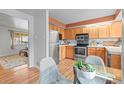 Well-lit kitchen features stainless appliances, warm wood cabinets, and adjacent dining area at 10050 W 8Th Pl, Lakewood, CO 80215