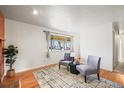 Inviting living room with hardwood floors, a cozy rug, and stylish seating, creating a comfortable and airy space at 10050 W 8Th Pl, Lakewood, CO 80215