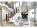 Elegant living area featuring a modern fireplace, stylish decor, and an open staircase with wood and metal railings at 4401 S Clarkson St, Englewood, CO 80113