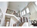 Grand staircase with modern railings leading to an upper level with soaring ceilings and large windows at 4401 S Clarkson St, Englewood, CO 80113