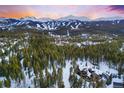 A stunning snow-covered home nestled in mountains and lush green trees at 327 Peerless Dr, Breckenridge, CO 80424
