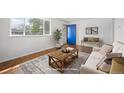 Bright living room showcasing a cozy sofa, wooden coffee table, and a blue front door at 7987 Durango St, Denver, CO 80221