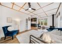 Cozy living room with wood ceiling, plush rug, blue accents, and open floor plan to kitchen at 154 Apache Rd, Evergreen, CO 80439