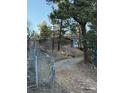 Exterior view of a home at the end of a gravel driveway surrounded by foliage at 433 Gunn Ave, Berthoud, CO 80513