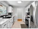 Bright kitchen with white cabinets, stainless steel appliances, and black backsplash at 7216 S Lincoln Way, Centennial, CO 80122