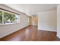 Spacious bedroom with hardwood floors, two large windows, and a decorative wood accent wall at 3150 W Mexico Ave, Denver, CO 80219