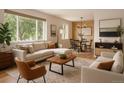 Bright living room featuring modern furnishings, large windows, hardwood floors, and an adjacent dining area at 3150 W Mexico Ave, Denver, CO 80219