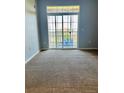 Living room featuring neutral carpet, sliding glass doors to private deck for relaxing outdoor living at 7440 S Blackhawk St # 207, Englewood, CO 80112