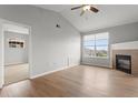Bright living room featuring vaulted ceilings, a cozy fireplace, and hardwood floors, creating an inviting and stylish space at 7440 S Blackhawk St # 207, Englewood, CO 80112