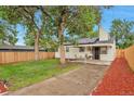 Serene backyard featuring a covered patio, a well-manicured lawn, and a privacy fence at 1325 Dayton St, Aurora, CO 80010