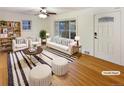 Bright, virtually staged living room with hardwood floors, stylish furniture, and a large sliding glass door at 1920 Alton St, Aurora, CO 80010