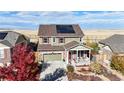 Two-story house with green siding, red door, and solar panels at 3158 S Nepal Way, Aurora, CO 80013