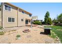Spacious backyard showcasing a fire pit area, a deck, and ample space for outdoor activities at 4860 E 120Th Pl, Thornton, CO 80241