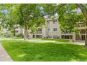 Exterior view of a condo building surrounded by lush trees and a green lawn at 20 S Boulder Cir # 2109, Boulder, CO 80303