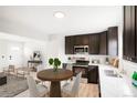 Eat-in kitchen features stainless steel appliances, white countertops, and dark cabinetry at 13202 Olmsted Pl, Denver, CO 80239