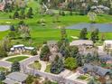 Stunning aerial view of homes nestled in a lush, green golf course community with lake at 5365 W Princeton Dr, Denver, CO 80235