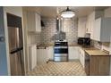 Updated kitchen featuring stainless steel appliances, granite countertops, subway tile backsplash and unique flooring at 705 S Alton Way # 6B, Denver, CO 80247