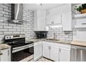 Bright updated kitchen featuring white cabinets, granite countertops, stainless appliances and subway tile backsplash at 705 S Alton Way # 6B, Denver, CO 80247