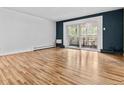 Spacious living room featuring hardwood floors, a neutral wall color, and sliding doors to the balcony at 705 S Alton Way # 6B, Denver, CO 80247
