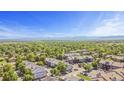 Scenic aerial view of the neighborhood with lush greenery, mountains in the distance, and clear blue skies at 10784 W 63Rd Pl # 205, Arvada, CO 80004