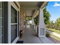 Inviting covered porch featuring brick accents, white columns, and ample space for relaxation at 9530 Gray St, Westminster, CO 80031