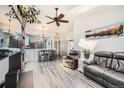 Open-concept living room with hardwood floors and vaulted ceiling leading to dining and kitchen areas at 10510 W Fair Ave # A, Littleton, CO 80127