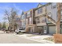 Street view of colorful townhomes with garages and mature trees at 12031 E Ford Cir, Aurora, CO 80012