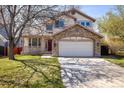 Charming two-story home featuring a stone facade, two-car garage, and well-maintained lawn at 4565 Pussywillow Ct, Boulder, CO 80301