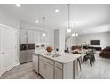 Open-concept kitchen boasts a large island with granite countertops and stainless steel appliances at 13465 Valentia Pl, Thornton, CO 80602