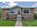 Close up of the exterior showcases a stone facade with a well-manicured lawn and walkway leading to the front door at 3354 S Flower St # 52, Lakewood, CO 80227