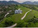 Aerial view of a luxury home set on a sprawling green landscape with winding roads at 15175 W Belleview Ave, Morrison, CO 80465