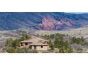 Exterior of home with tile roof nestled among trees and rolling hills, offering a peaceful retreat with scenic views at 15175 W Belleview Ave, Morrison, CO 80465