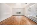 Bright living room featuring hardwood floors, white walls, and a large bay window at 3306 S Uinta Ct, Denver, CO 80231