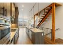 Contemporary kitchen with island, stainless appliances, and open staircase access at 2680 Blake St # 4, Denver, CO 80205