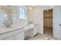 Modern bathroom with double vanity, marble floors, and glass-enclosed shower at 28644 E 7Th Ave, Watkins, CO 80137