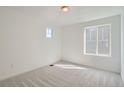 Well-lit bedroom with two windows, neutral carpet, and white walls at 28644 E 7Th Ave, Watkins, CO 80137