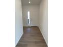 View of the entryway with light wood floors and white walls leading to the front door at 28644 E 7Th Ave, Watkins, CO 80137