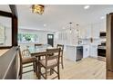 Light-filled living and dining area with modern light fixtures and hardwood floors at 1226 W 98Th Ave, Northglenn, CO 80260