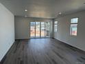 Bright, open-concept living room with hardwood floors and sliding glass doors that let in natural light at 2668 Simpson Ln, Erie, CO 80026